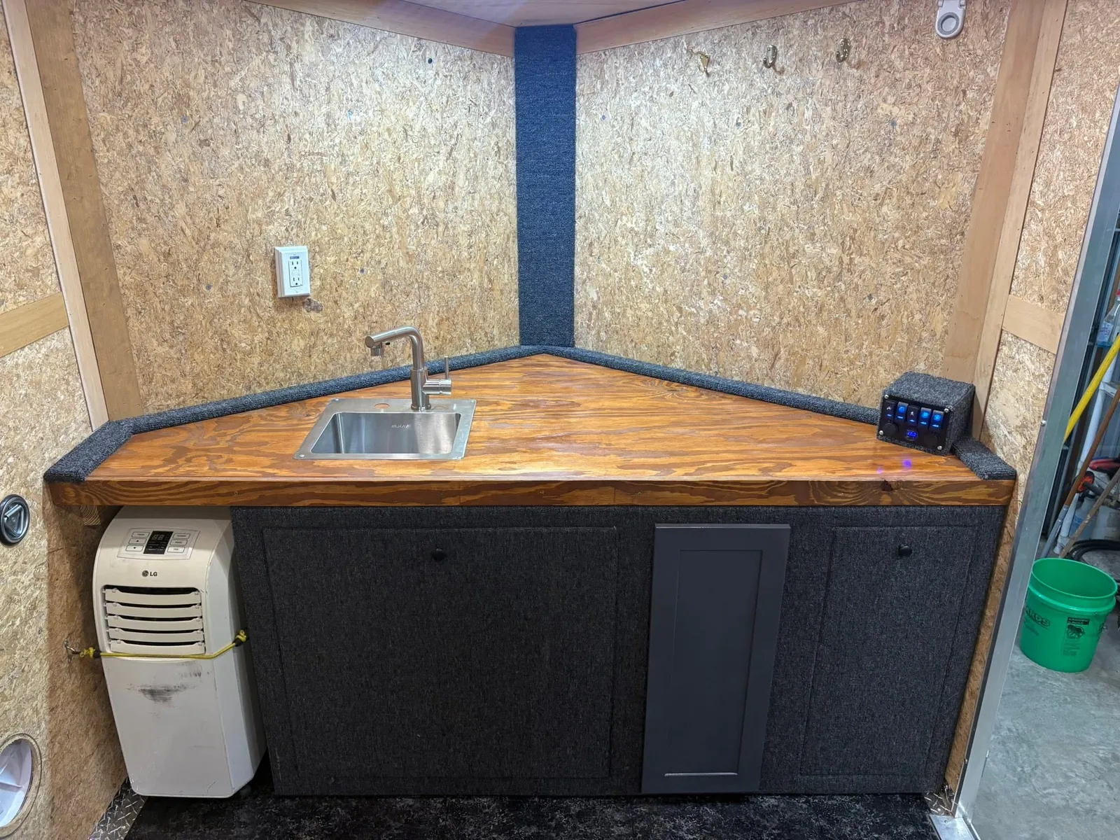 Front counter with a sink, a 12V switch panel and room for a portable AC unit.