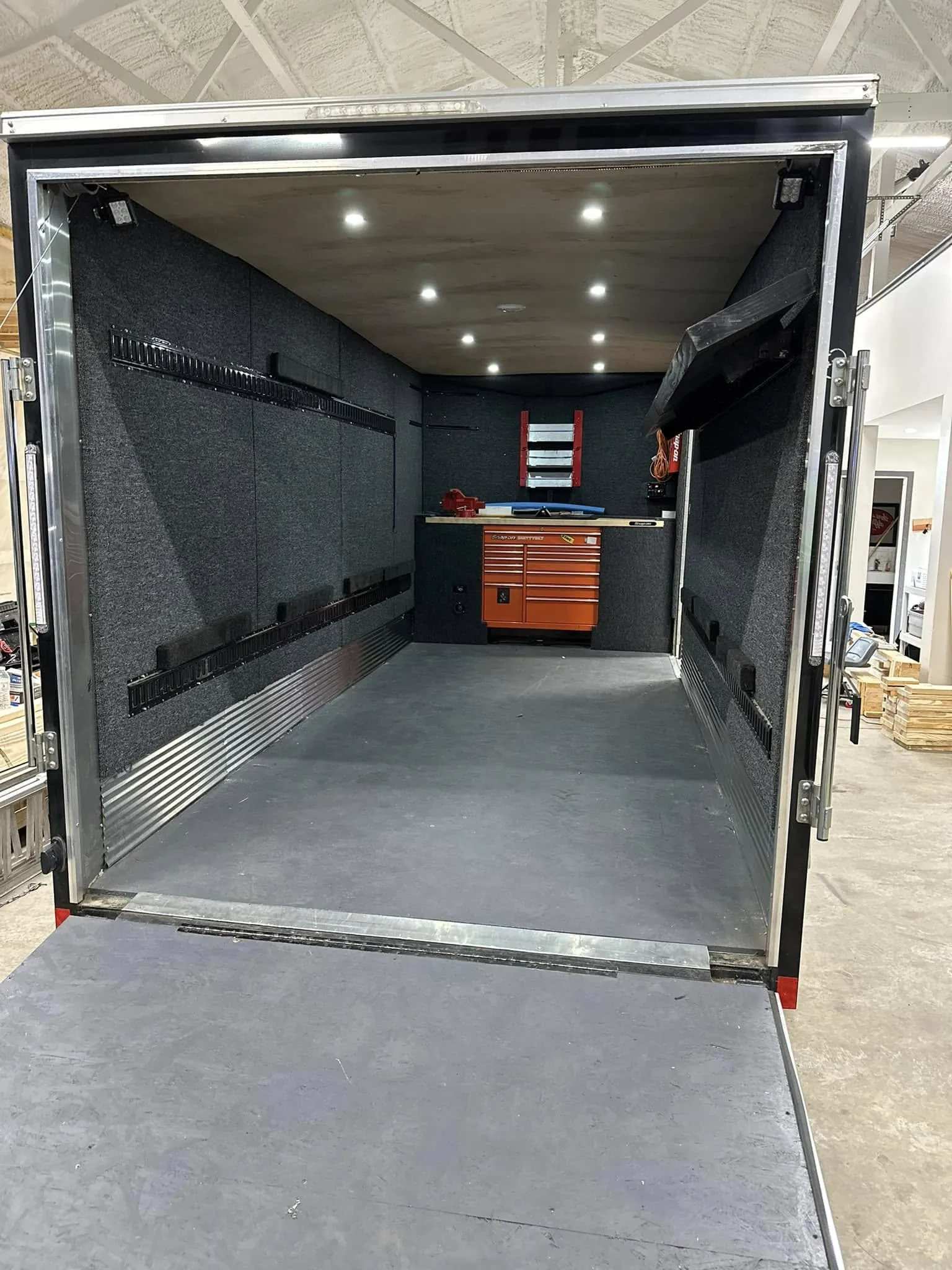 Mobile tool trailer: carpeted walls, E-track, a workbench and toolbox, LED lighting.